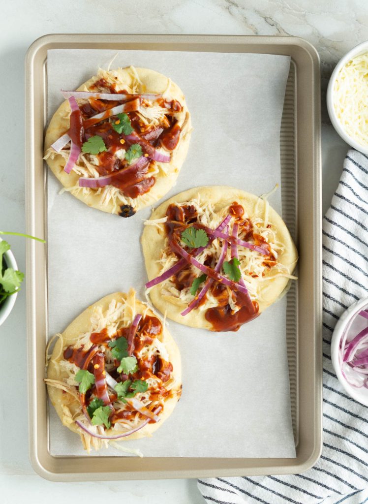 Three BBQ Chicken Flatbreads on a baking sheet lined with parchment paper