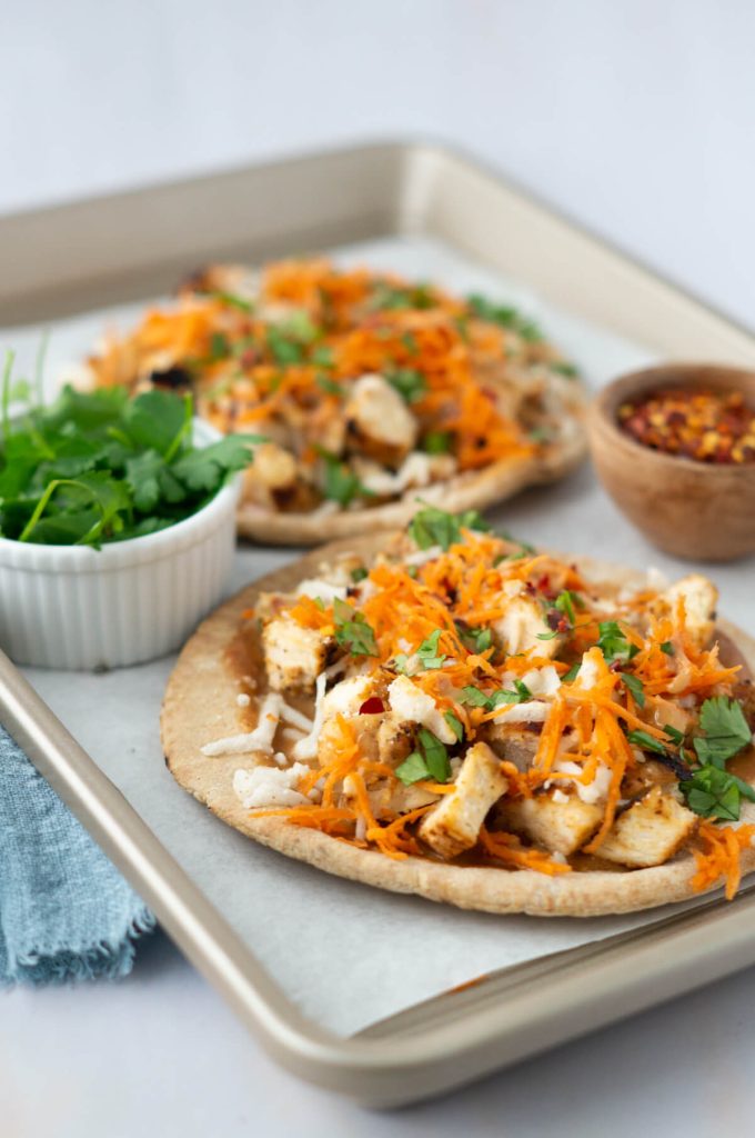 Two Thai Chicken Pizzas on a baking sheet