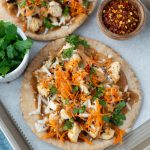 Two Thai Chicken Flatbread Pizzas on a baking sheet