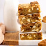 Stack of four Biscoff blondies with a glass of milk