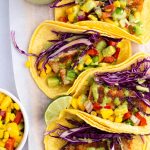 Four blackened mahi mahi fish tacos lined up in a vertical row.