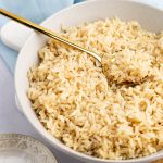 Brown Jasmine Rice in a bowl with a gold spoon.