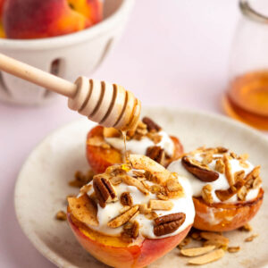 Photo of air fryer peaches with greek yogurt, granola, and honey.