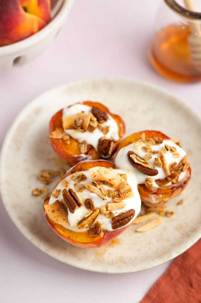 Photo of air fryer peaches with greek yogurt, granola, and honey.