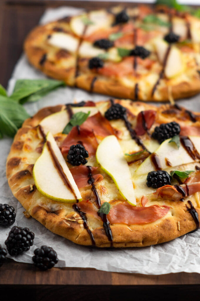 Photo of blackberry pizza with basil and blackberries.