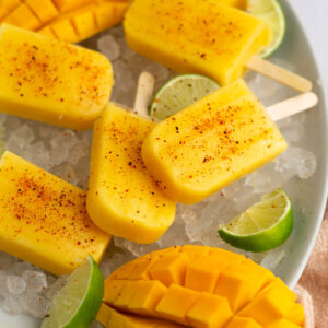 Mango popsicles on ice with lime and mango and Tajin.