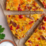 Southwest Frittata cut into slices with a small bowl of sour cream to the side.