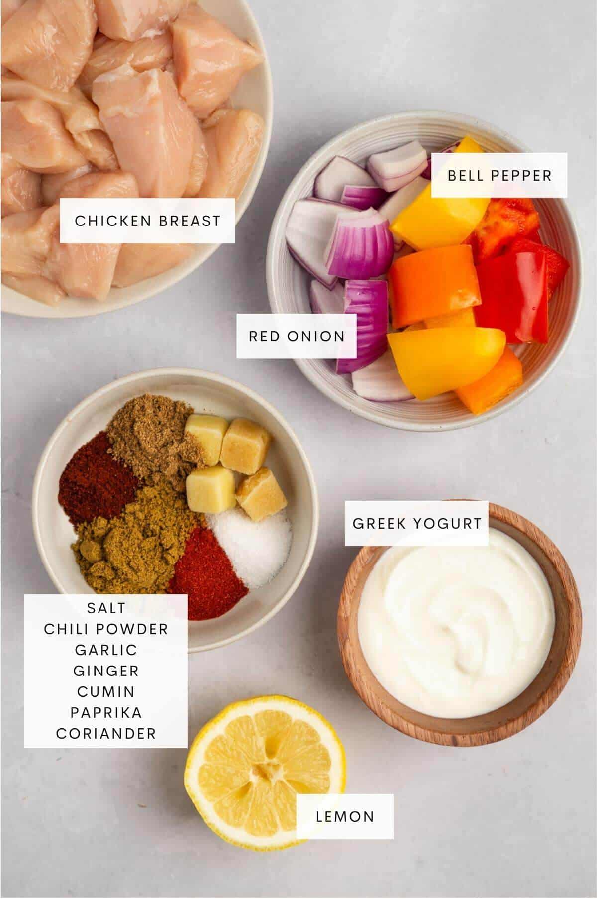Ingredients needed for Tandoori chicken kebabs: chicken breast, bell peppers, red onion, Greek yogurt, lemon, ginger, garlic, and spices.