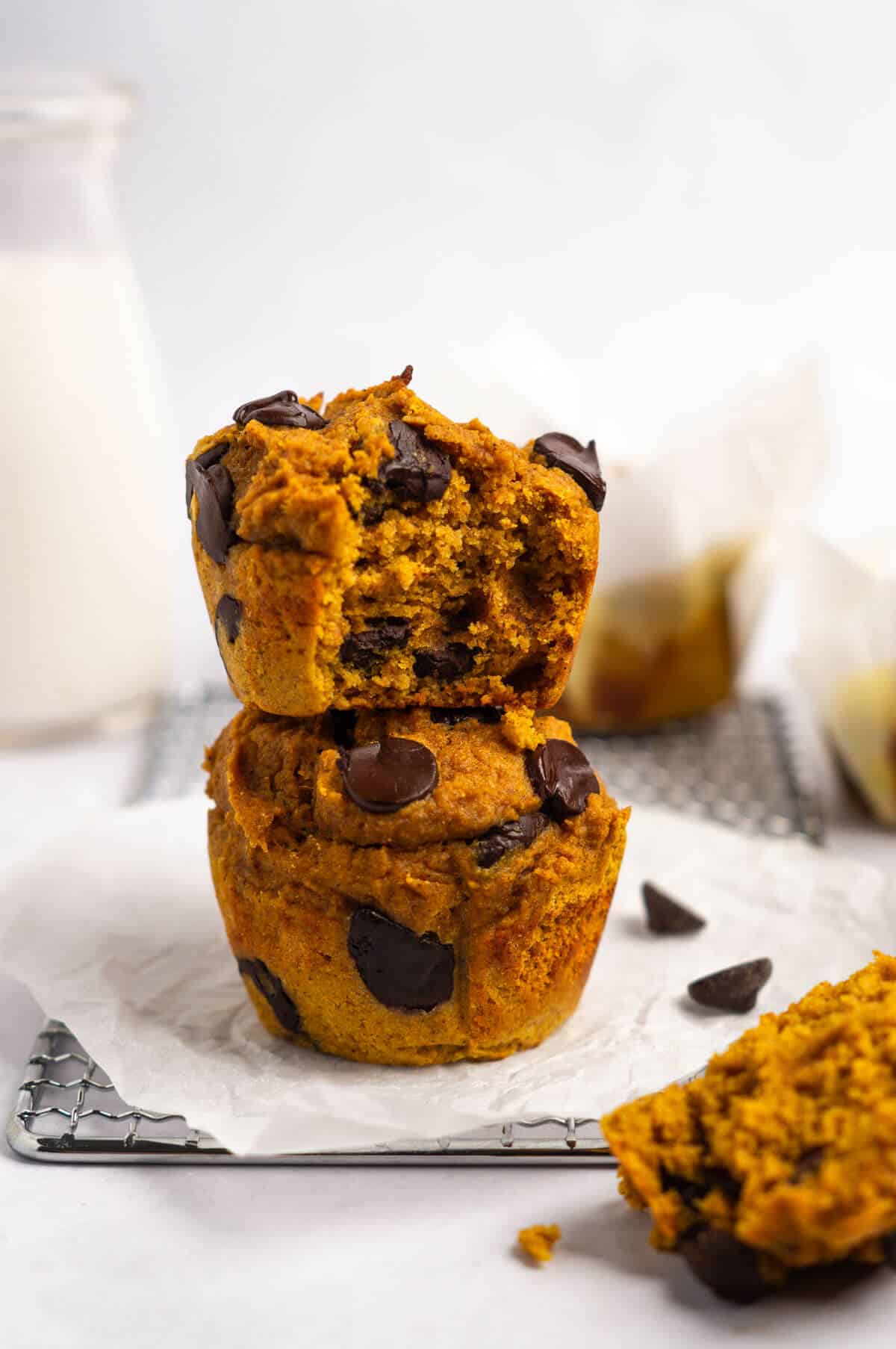 A stack of two pumpkin protein muffins with chocolate chips.