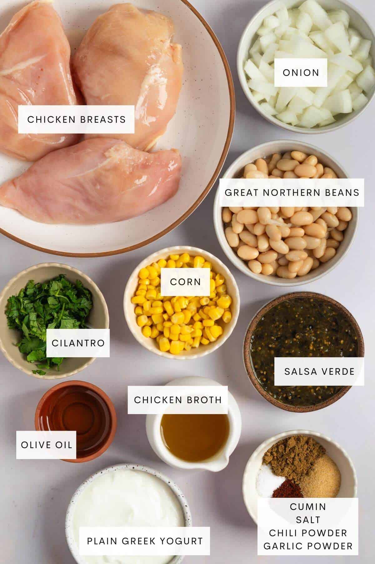 Chicken breasts, onion, great northern beans, corn, cilantro, chicken broth, salsa verde, cumin, salt, chili powder, garlic powder, plain greek yogurt, olive oil, and cilantro.