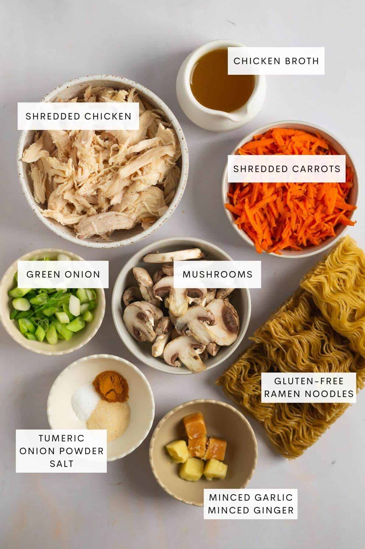 Shredded chicken, chicken broth, shredded carrots, green onion, mushrooms, gluten-free ramen noodles, tumeric, onion powder, salt, minced garlic, minced ginger, and gluten-free ramen noodles.