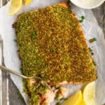 Pan of pesto crusted salmon and lemon.