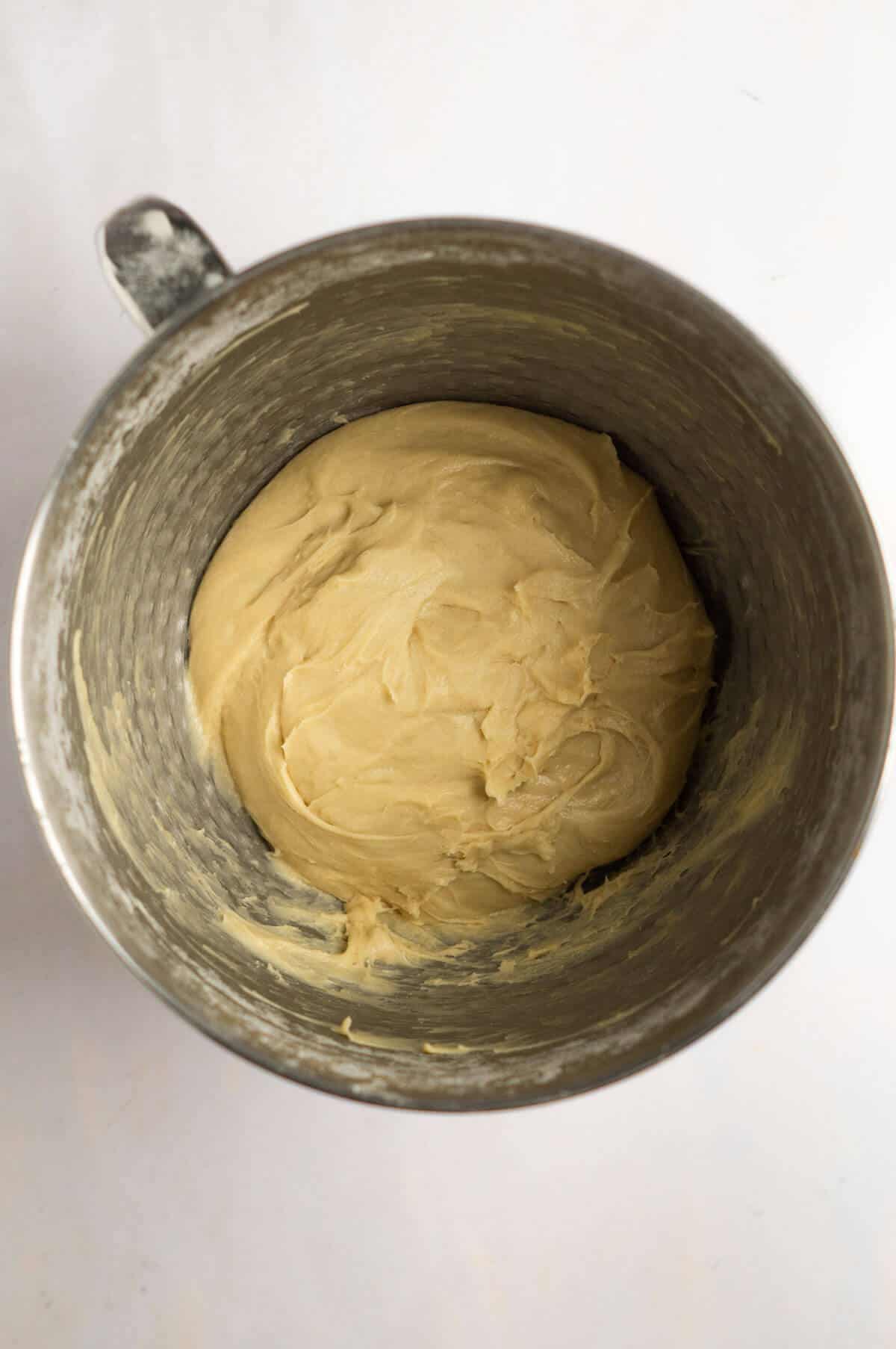A large mixing bowl with mixed cinnamon roll dough.