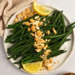 An overhead shot of a plate of honey roasted green beans with roasted cashews.