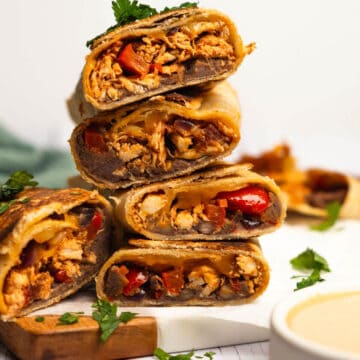 A stack of chicken fajitas wraps cut in half to show the inside of the wrap.