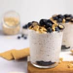 A glass with blueberry cheesecake overnight oats.