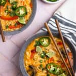 Two bowls of coconut curry ramen with chopsticks.
