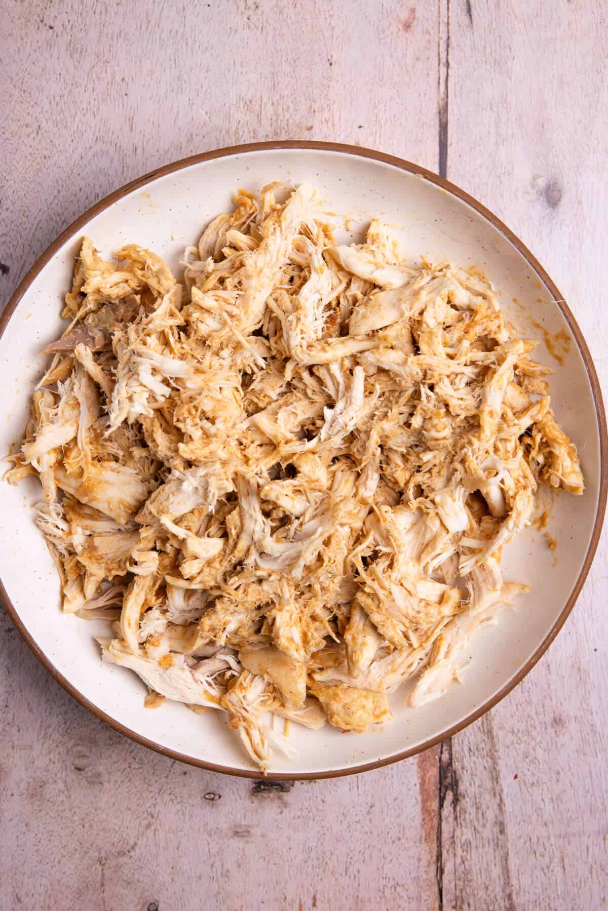 A plate of shredded chicken tossed in peanut sauce.