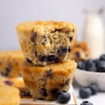 Two blueberry protein muffins stacked on top of each other.