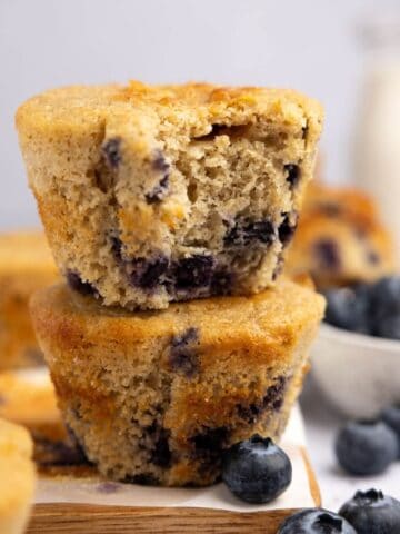 An up close shot of two blueberry protein muffins stacked on top of each other.