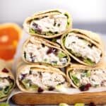 A stack of chicken salad wraps cut open to show the contents.