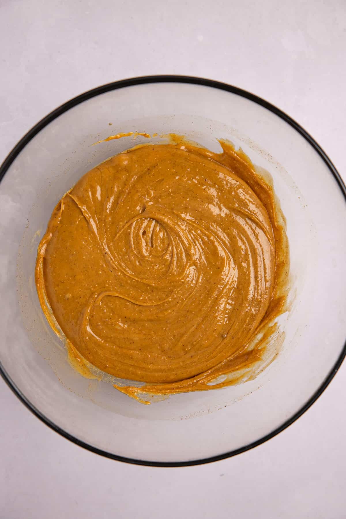 Picture of a bowl of peanut butter, honey, vanilla, and cinnamon mixed.