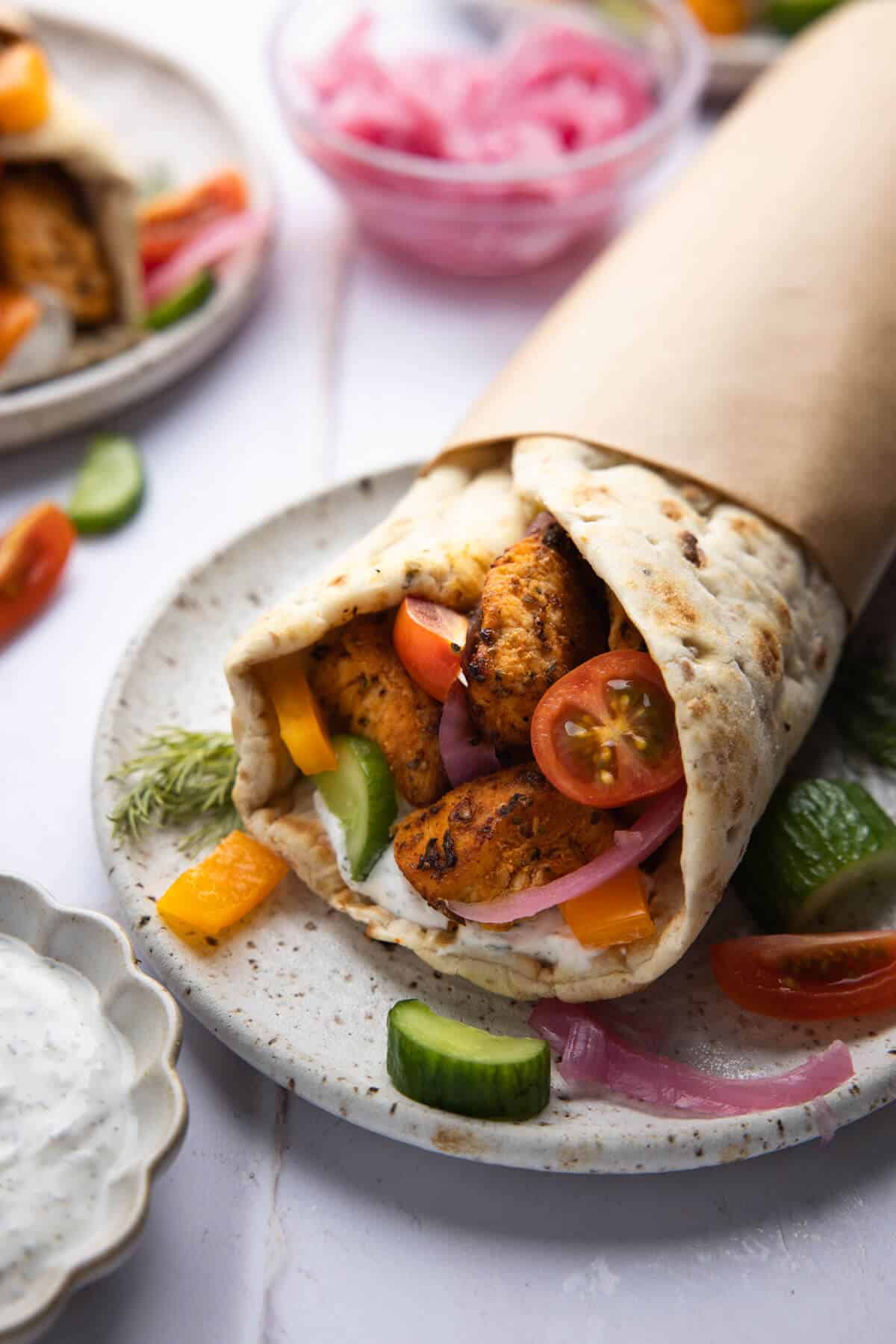 A front-facing shot of an assembled Greek chicken wrap.