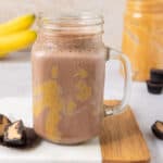 A glass jar with peanut butter cup smoothie.
