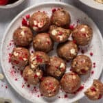 Plate of white chocolate raspberry protein balls.