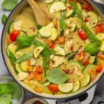 Large pot with green curry with chicken.