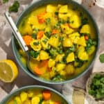 Two green soup bowls with turmeric chicken stew.