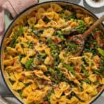 Bow tie vegetable pasta in a large pot with a wooden serving spoon.