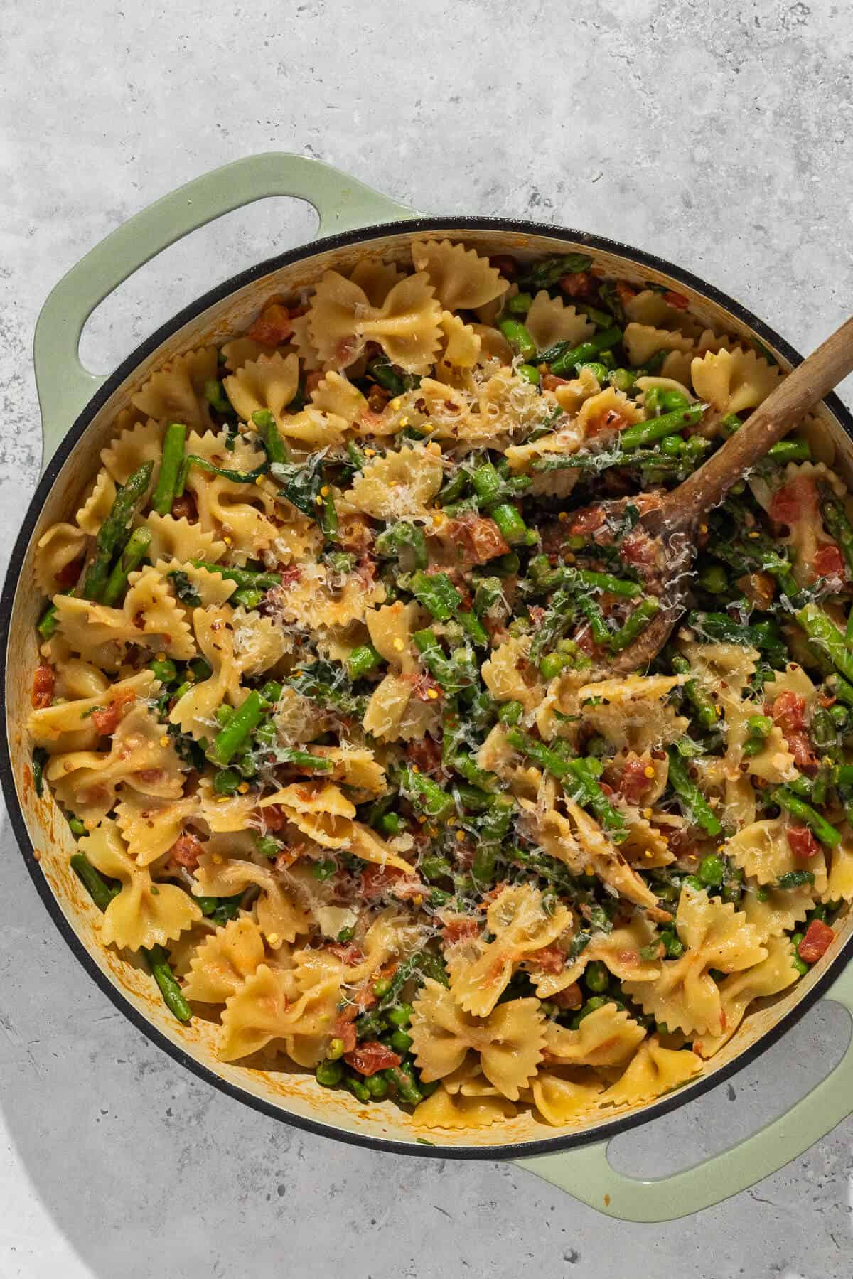 Large pot with completed bowtie pasta with spring vegetables.