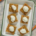 A serving dish with six squares of baked oats and yogurt topping.