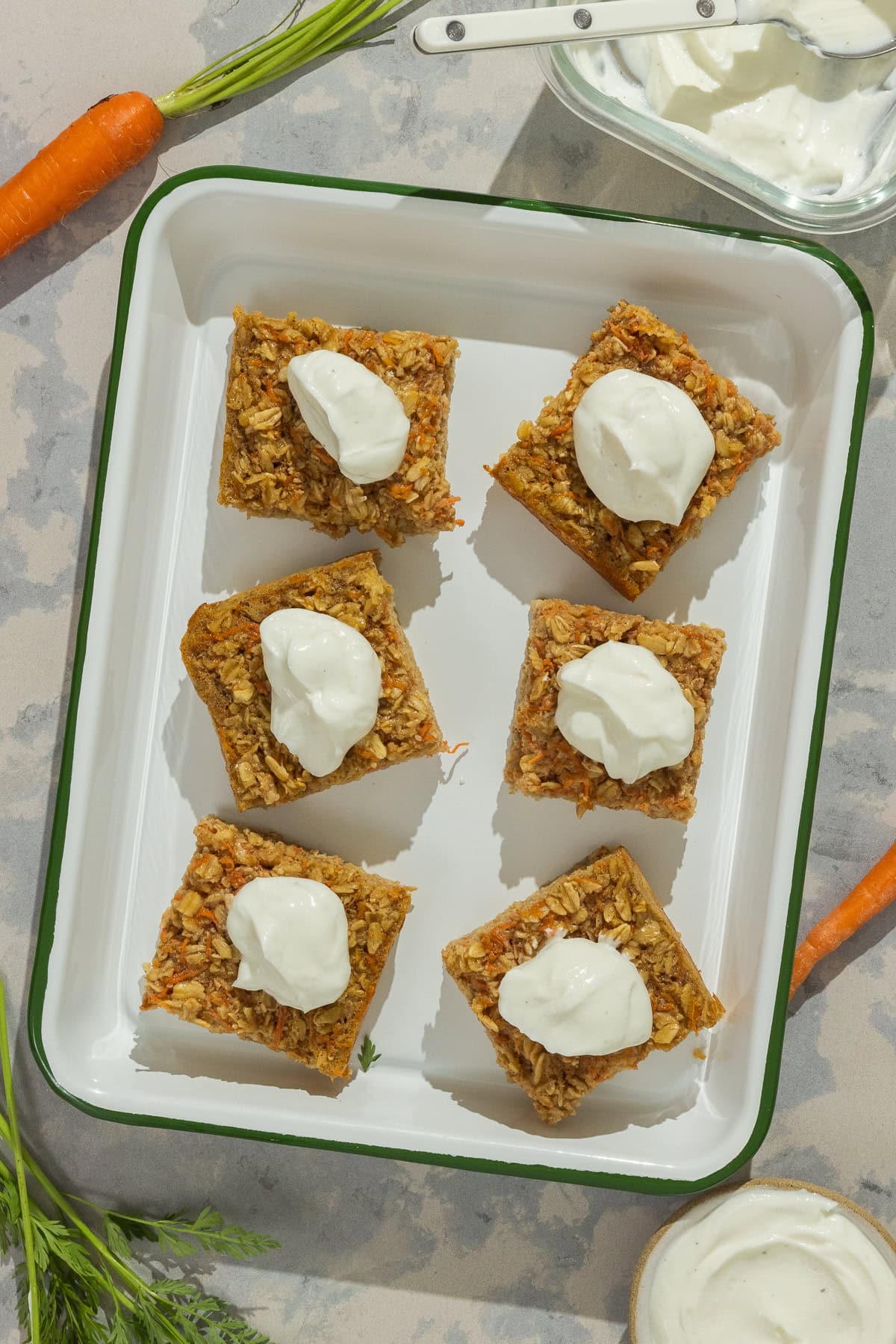 A serving dish with six squares of baked oats and yogurt topping.