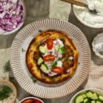 A plate with a prepared Greek smash pita.