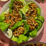 A plate with five prepared ground pork lettuce wraps.