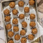 A small sheet pan with no bake cookie protein bites scattered across the pan.