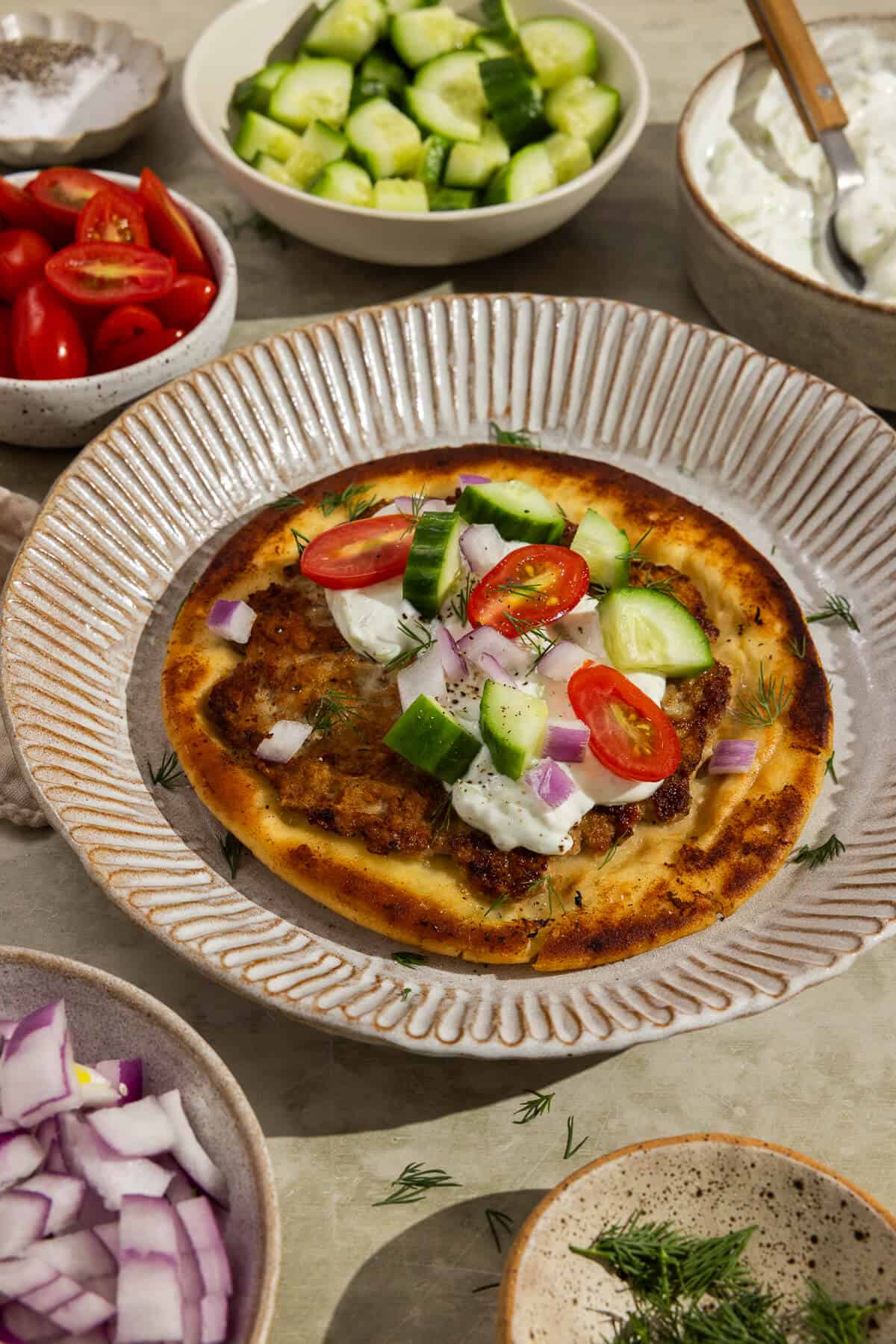 A plate with a prepared Greek smash pita.
