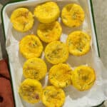 A baking dish with twelve sun-dried tomato basil egg bites.