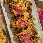 Closeup of pulled pork loaded baked potatoes.