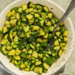 A bowl of completed cucumber edamame salad with a serving spoon.