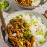 A bowl of honey sesame chicken with rice.