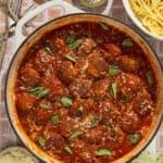A large skillet of meatballs in tomato sauce.