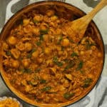 A large skillet of homemade hamburger helper with a wooden spoon.