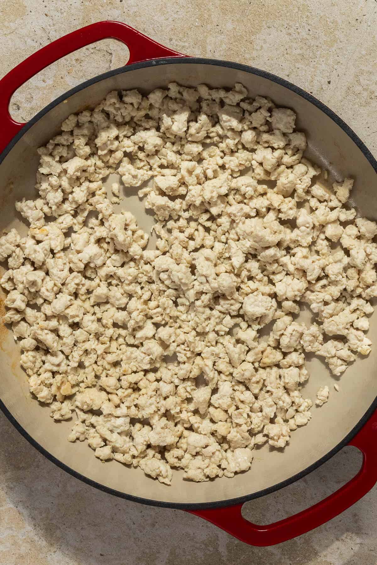 A skillet with cooked ground chicken.