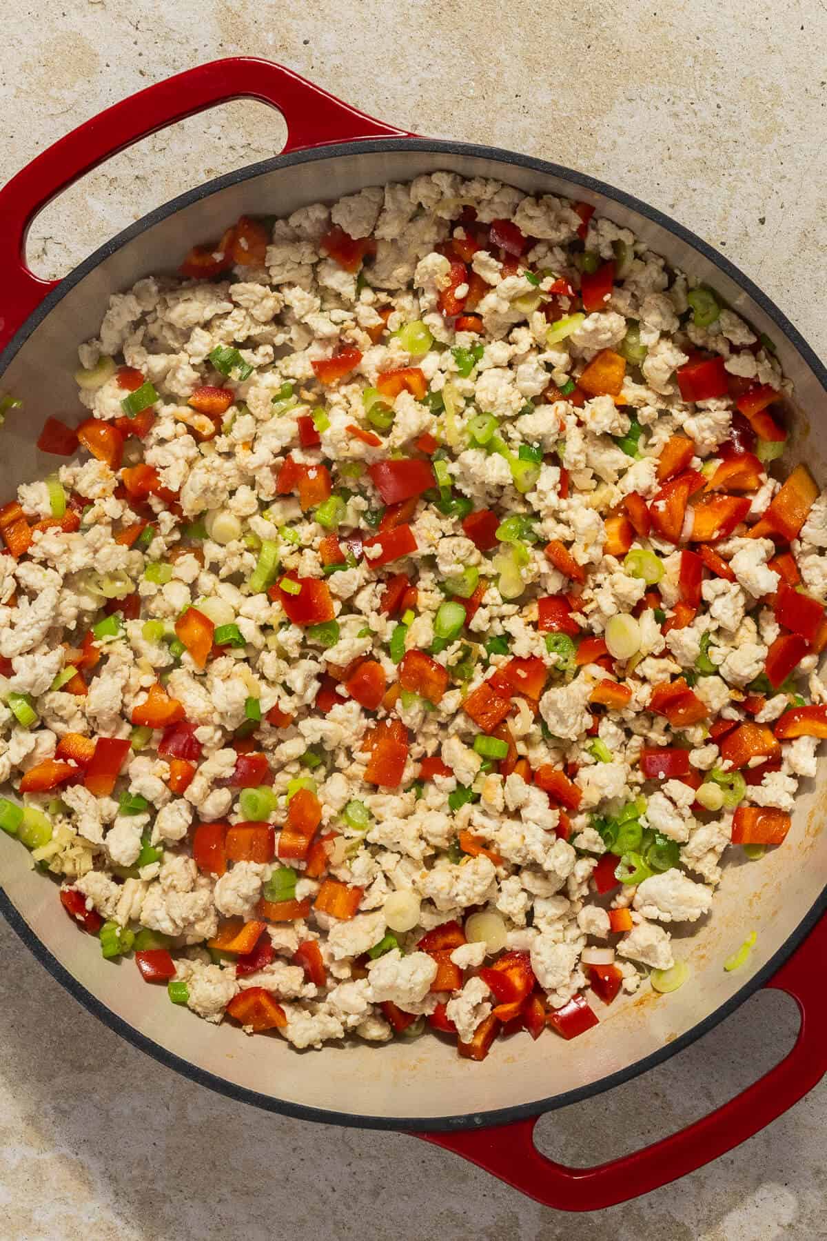 A skillet of cooked ground chicken and vegetables.