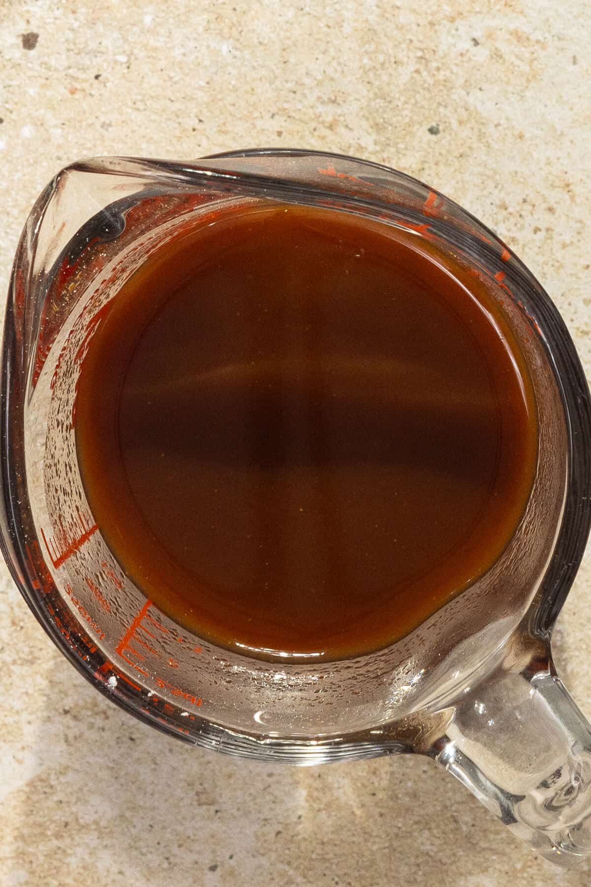 A pyrex measuring glass with the combined ingredients for the honey sriracha sauce.
