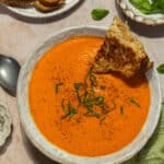 A bowl of high protein tomato soup with grilled cheese.