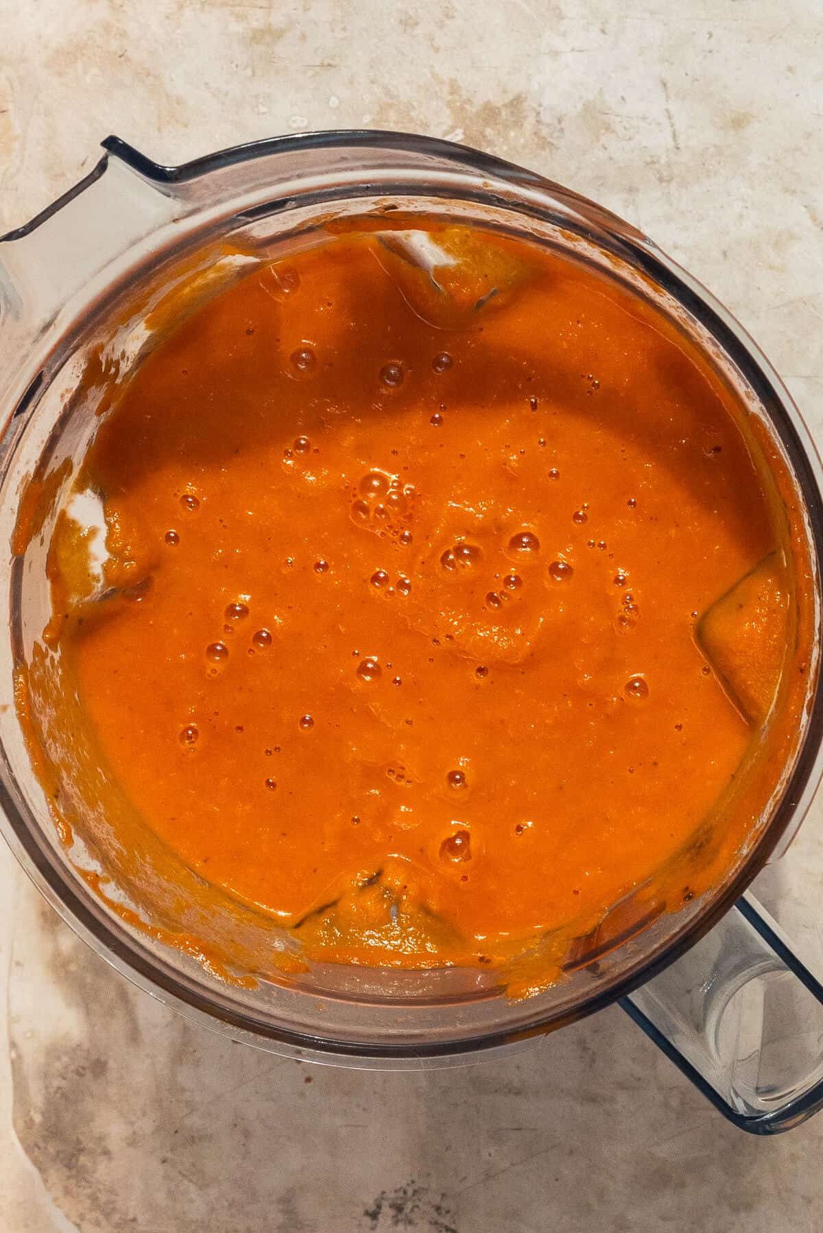 A blender with the blended tomato soup.